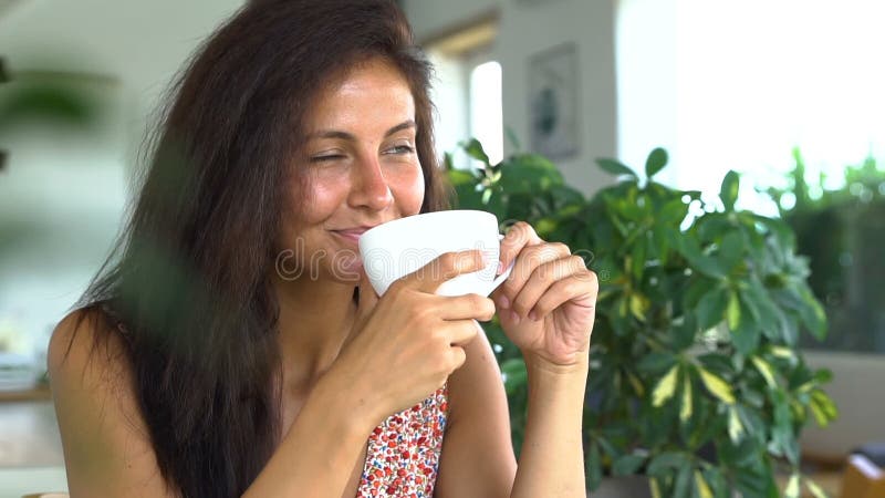 Härlig lycklig kvinna som dricker kaffe och att le