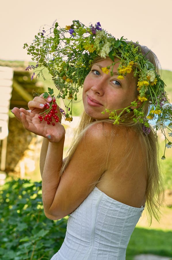 Härlig lång-vit hårkvinna i den vita klänning- och blommakransen att hålla i handgrupp av bär för röd vinbär Sommardag som är var arkivfoton Härlig lång-vit hårkvinna i den vita klänning- och blommakransen att hålla i handgrupp av bär för röd vinbär Sommardag som är var arkivfoton