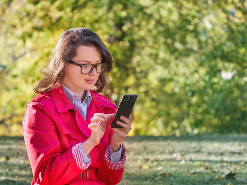 Härlig messaging för ung kvinna på Smart-telefonen royaltyfria foton Härlig messaging för ung kvinna på Smart-telefonen royaltyfria foton