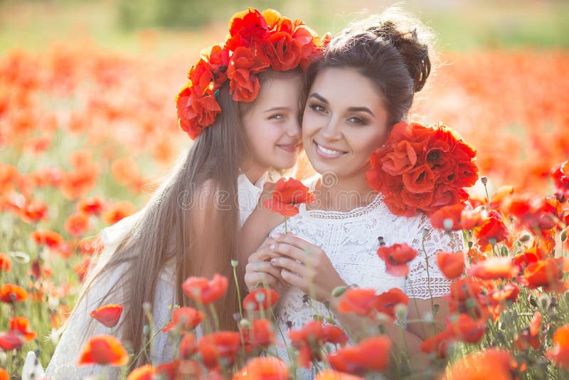 Härlig moder och hennes dotter som spelar i vårblommafält royaltyfri bild Härlig moder och hennes dotter som spelar i vårblommafält royaltyfri bild