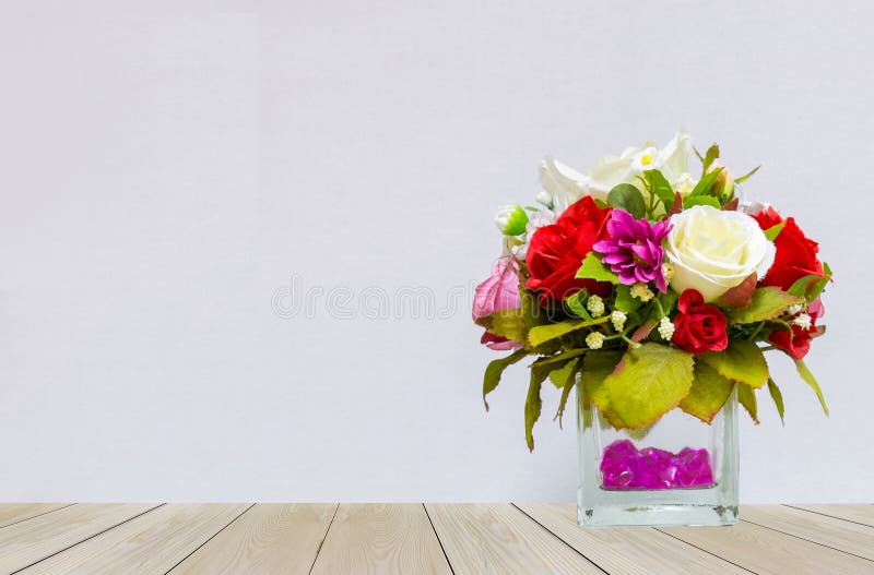 Härlig mång- färg av rosor i den Glass blomkrukan på hörnet på trätabellen med Gray Background arkivfoton