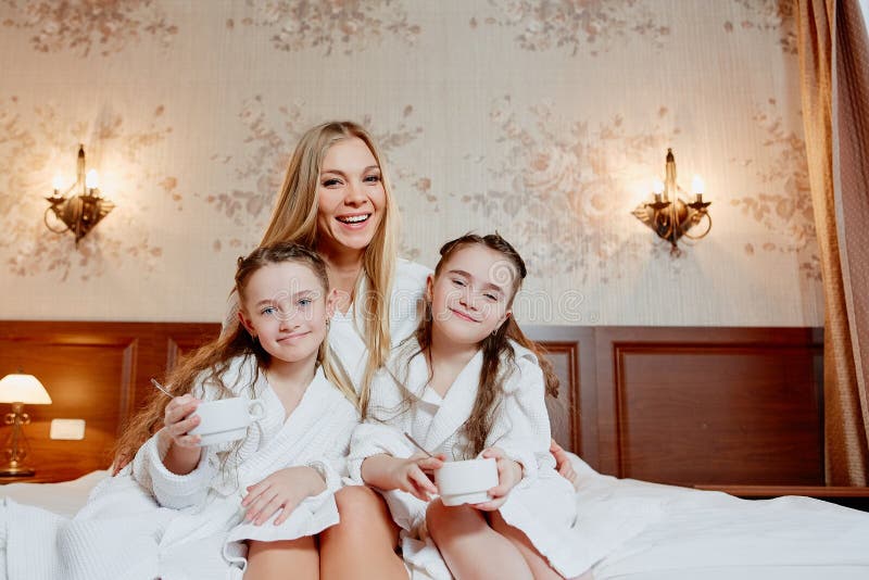 Härlig och lycklig moder och hennes två döttrar, omfamning och la royaltyfria bilder Härlig och lycklig moder och hennes två döttrar, omfamning och la royaltyfria bilder
