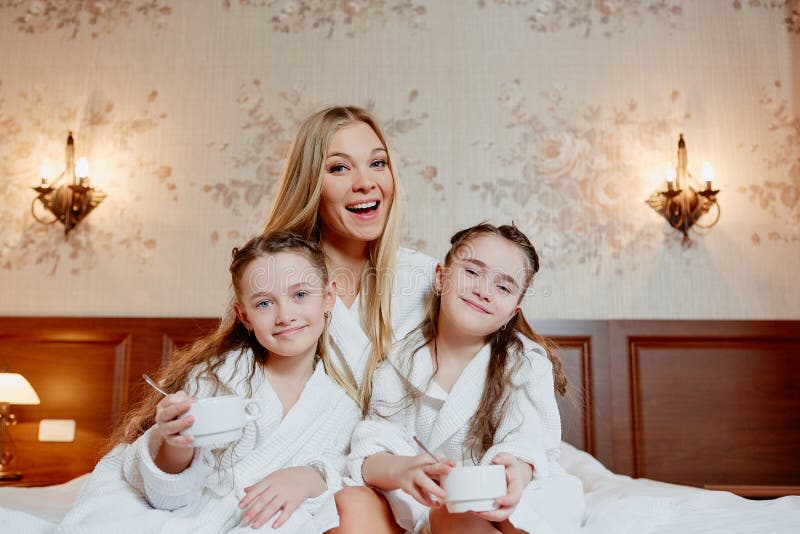 Härlig och lycklig moder och hennes två döttrar, omfamning och la royaltyfri fotografi Härlig och lycklig moder och hennes två döttrar, omfamning och la royaltyfri fotografi