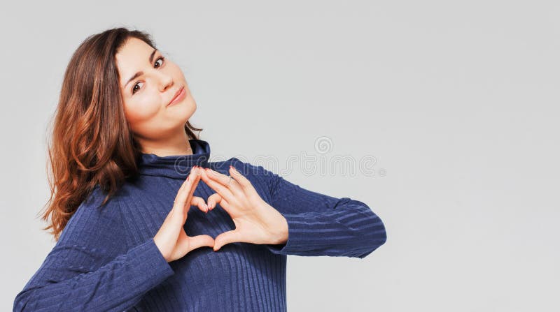 Härlig romantisk brunettflicka som gör hjärtagest med händer fotografering för bildbyråer Härlig romantisk brunettflicka som gör hjärtagest med händer fotografering för bildbyråer