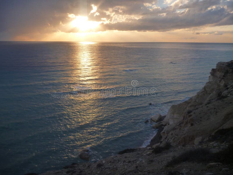 Härlig romantisk solnedgång på en stenig kust arkivfoto Härlig romantisk solnedgång på en stenig kust arkivfoto