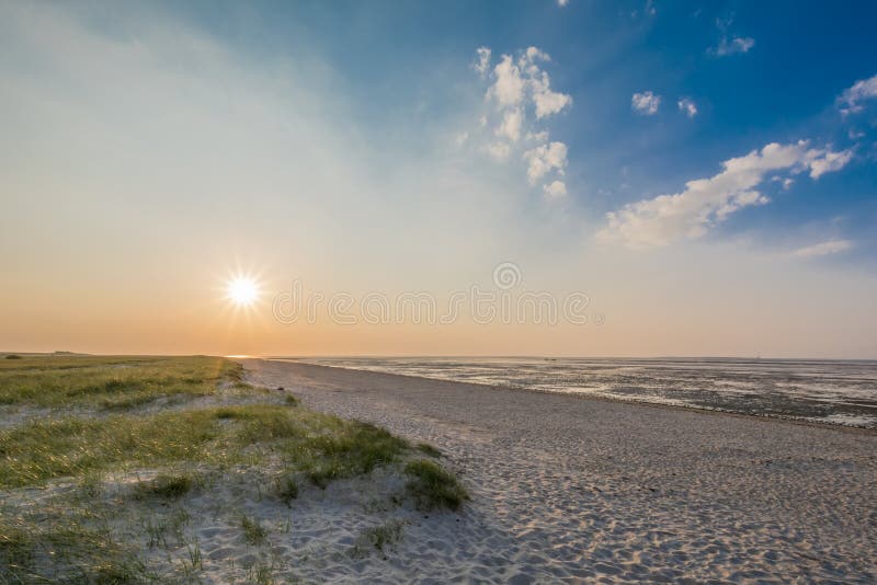 Härlig strand av den tyska Nordsjönsolnedgången arkivfoto Härlig strand av den tyska Nordsjönsolnedgången arkivfoto
