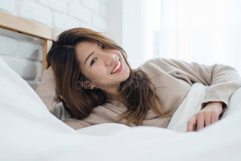Härlig ung asiatisk kvinna för stående på säng hemma i morgonen royaltyfri fotografi