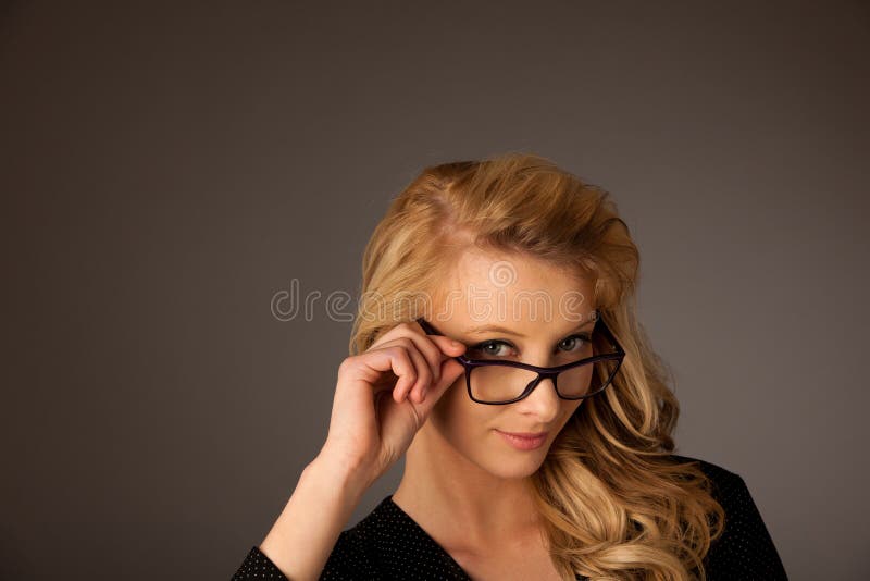 Härlig ung caucasian blond kvinna med ögonexponeringsglas som ser I royaltyfria foton Härlig ung caucasian blond kvinna med ögonexponeringsglas som ser I royaltyfria foton