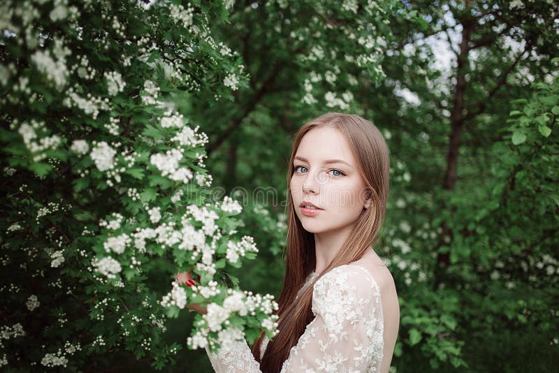 Härlig ung flicka i en blomninglila royaltyfri bild