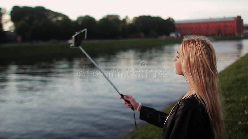 Härlig ung flicka som tar selfie på solnedgången HD