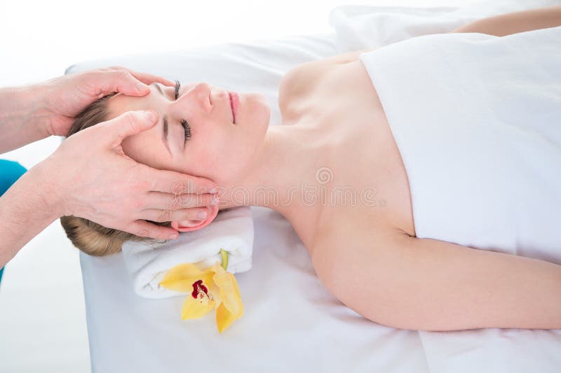 Härlig ung kvinna i en brunnsort som har en avslappnande head massage fr royaltyfria bilder Härlig ung kvinna i en brunnsort som har en avslappnande head massage fr royaltyfria bilder