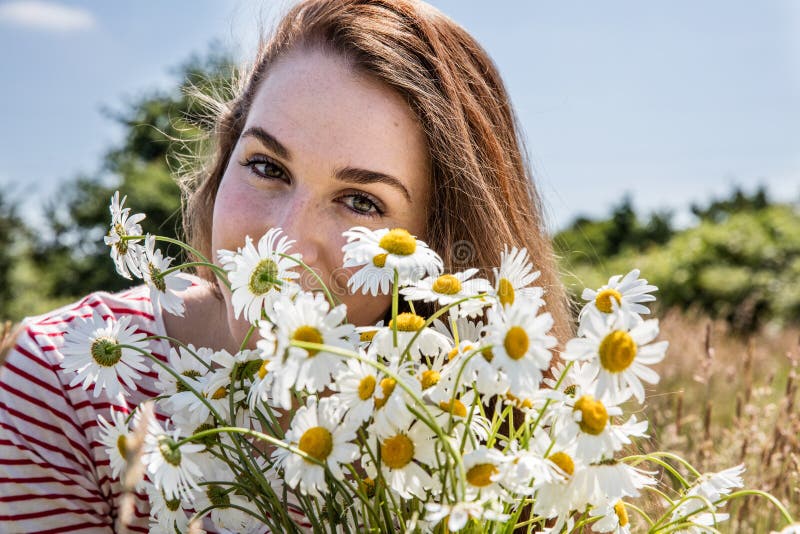 Härlig ung kvinna med blommabuketten som ler för naturlig skönhet arkivfoto Härlig ung kvinna med blommabuketten som ler för naturlig skönhet arkivfoto