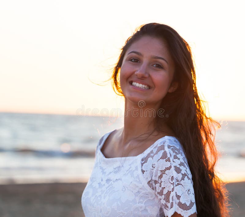 Härlig ung tonåring med en vit klänning på stranden på solar royaltyfri foto Härlig ung tonåring med en vit klänning på stranden på solar royaltyfri foto
