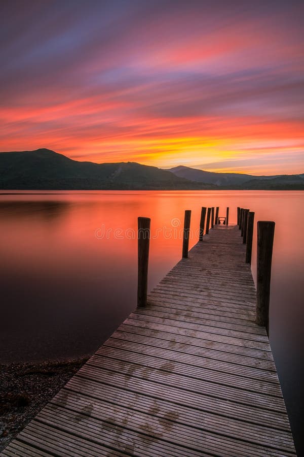 Härlig vibrerande solnedgång över den Ashness bryggan i Keswick, sjöområdet, Cumbria, UK royaltyfri bild Härlig vibrerande solnedgång över den Ashness bryggan i Keswick, sjöområdet, Cumbria, UK royaltyfri bild