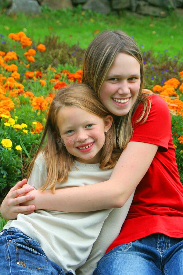 Two young pretty girls that could be sisters, or cousins or a babysitter hanging out with the youngster. Two young pretty girls that could be sisters, or cousins or a babysitter hanging out with the youngster