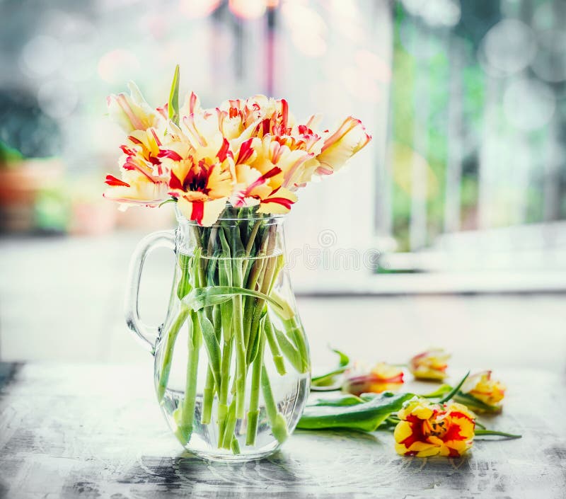 Härliga fläckiga tulpan samlar ihop i den glass vasen på fönstret med vårnaturen Papegojatulpan fotografering för bildbyråer Härliga fläckiga tulpan samlar ihop i den glass vasen på fönstret med vårnaturen Papegojatulpan fotografering för bildbyråer