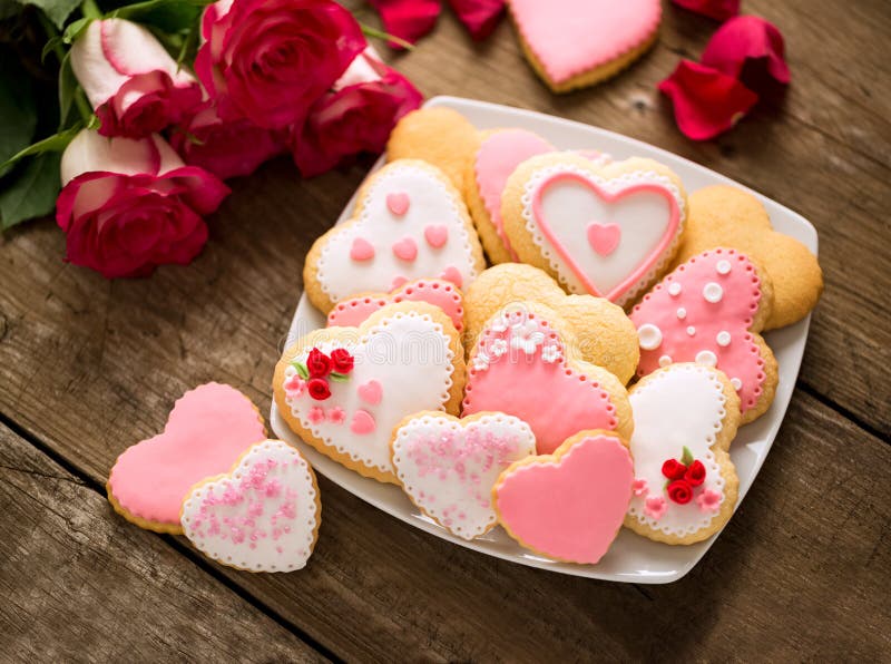 Beautiful tasty valentine day cookies and roses on vintage desk. Beautiful tasty valentine day cookies and roses on vintage desk