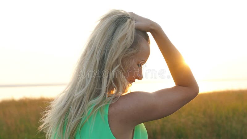 Härligt blont gå i ett fält på solnedgången, närbild lager videofilmer