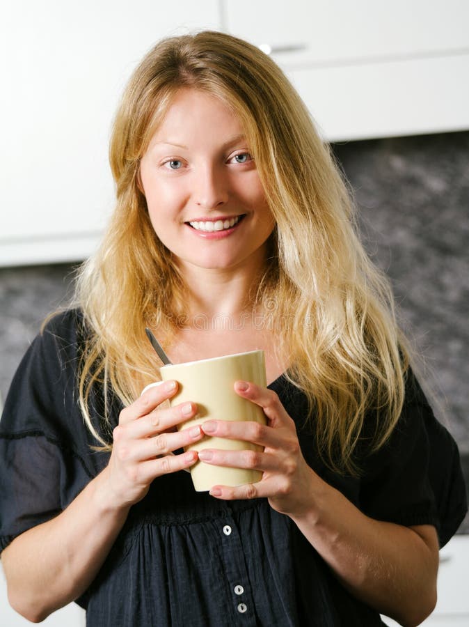 Härligt blont i köket med kaffe arkivfoto Härligt blont i köket med kaffe arkivfoto
