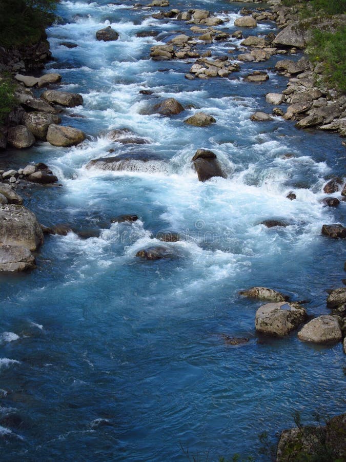 Härligt blått vatten i floden i den gröna vallen