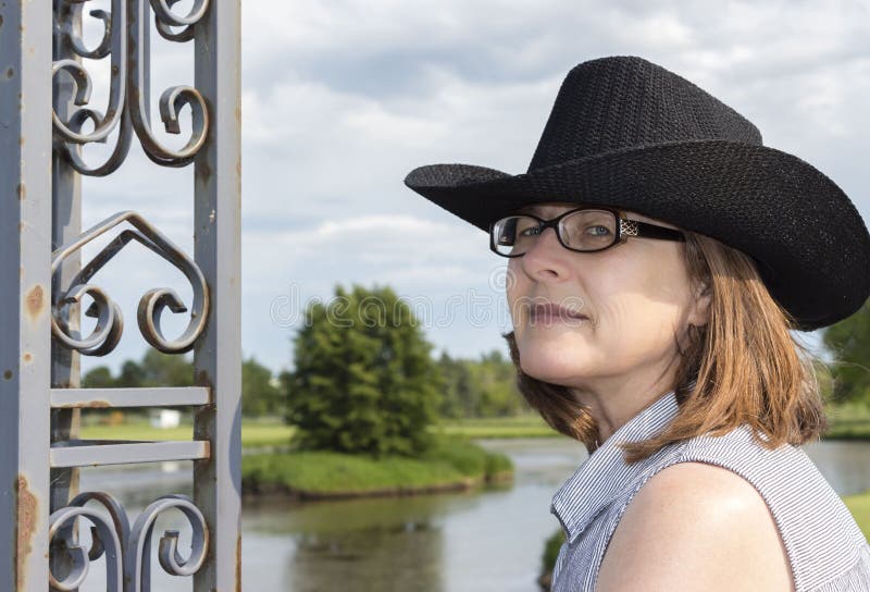 Härligt huvudskott av bärande exponeringsglas för en kvinna och en svart cowboyhatt arkivfoton Härligt huvudskott av bärande exponeringsglas för en kvinna och en svart cowboyhatt arkivfoton