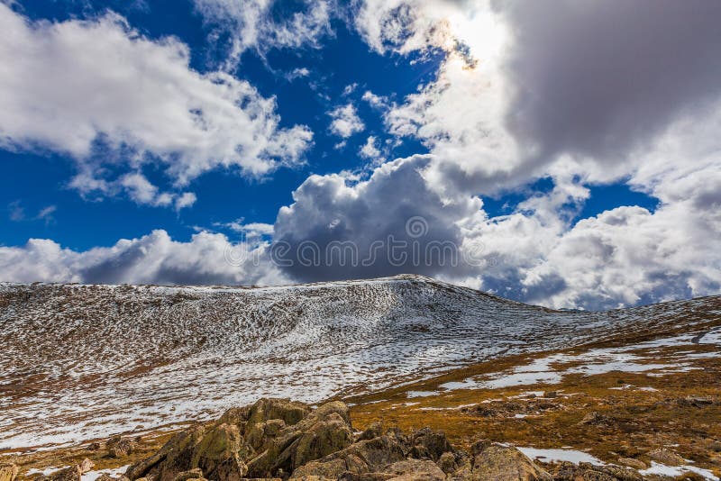 Härligt landskap av snö-täckte berg och fluffiga moln royaltyfri bild Härligt landskap av snö-täckte berg och fluffiga moln royaltyfri bild