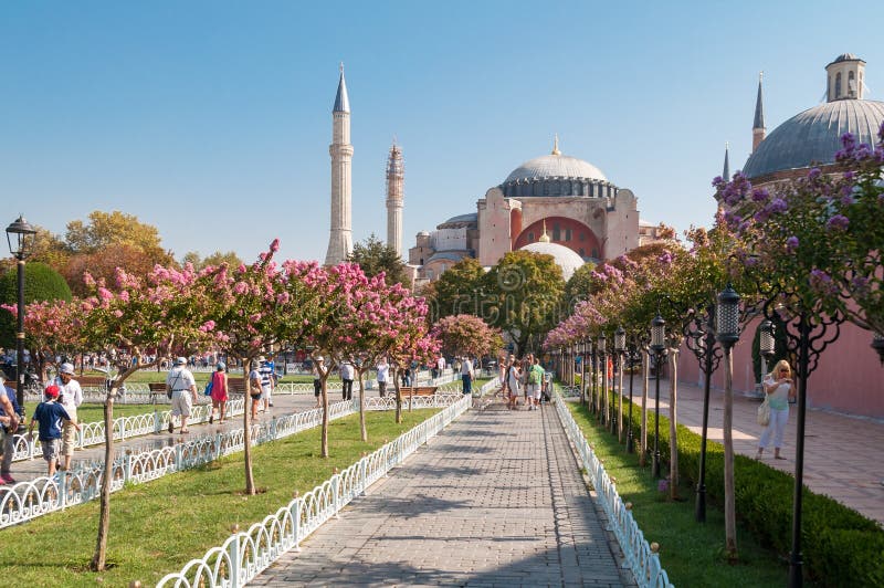 Härligt parkera gränden med turister och den Hagia Sophia gränsmärket på bakgrunden arkivfoto Härligt parkera gränden med turister och den Hagia Sophia gränsmärket på bakgrunden arkivfoto