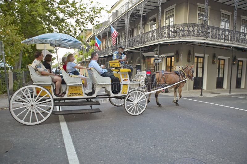 Hästvagn och turister i fransk fjärdedel av New Orleans, Louisiana royaltyfri foto Hästvagn och turister i fransk fjärdedel av New Orleans, Louisiana royaltyfri foto