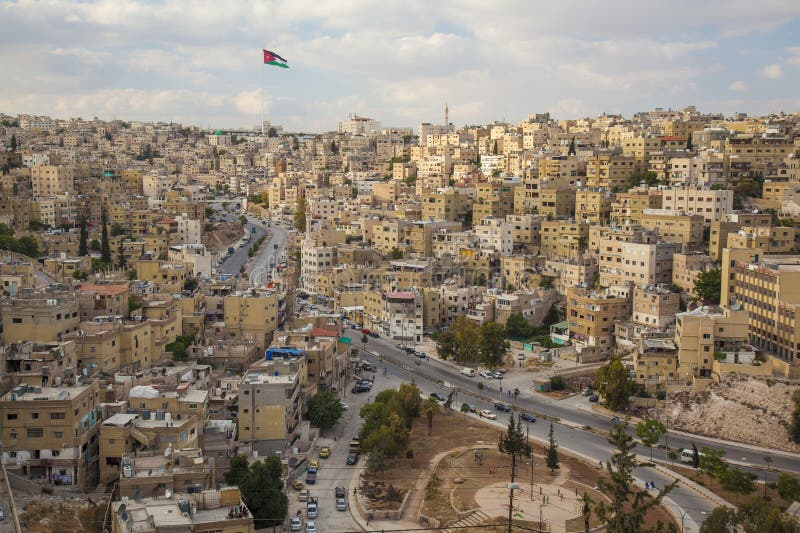 Häuser auf den Hügeln von im Stadtzentrum gelegenem Amman mit Jordanien-Flagge