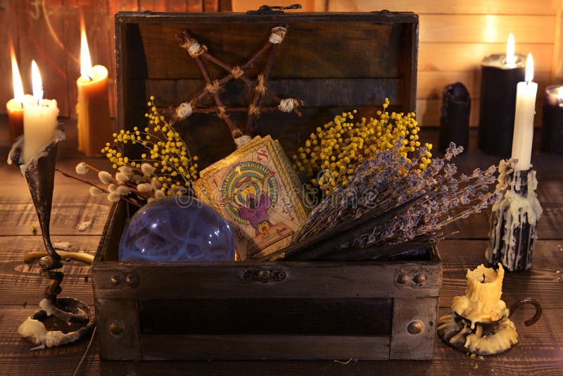 Witch box with healing herbs, crystal ball, tarot cards and burning candles. Wicca, esoteric, divination and occult background with vintage magic objects for mystic rituals. Witch box with healing herbs, crystal ball, tarot cards and burning candles. Wicca, esoteric, divination and occult background with vintage magic objects for mystic rituals