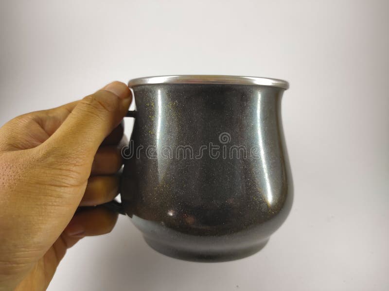 Portrait of a left hand holding a black mug isolated on a white background. Portrait of a left hand holding a black mug isolated on a white background