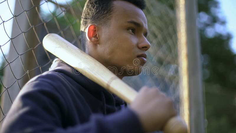 Hållande baseballslagträ för tonårs- pojke, ungdomliga i gettot, barnslig brottslighet arkivfoton Hållande baseballslagträ för tonårs- pojke, ungdomliga i gettot, barnslig brottslighet arkivfoton
