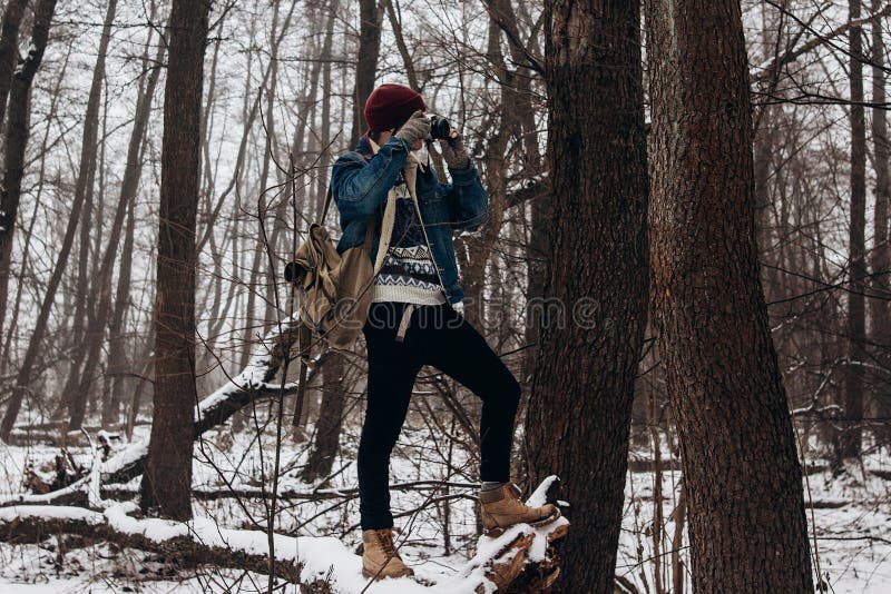 Hållande kamera för stilfull hipsterhandelsresande och danandefoto i snö arkivfoto Hållande kamera för stilfull hipsterhandelsresande och danandefoto i snö arkivfoto