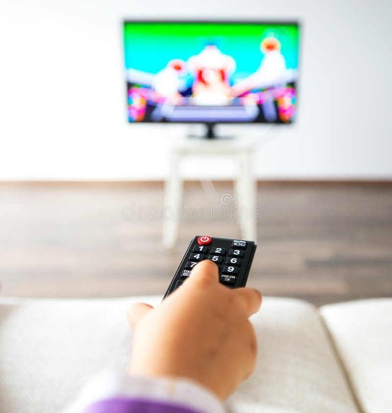 Hållande ögonen på TV för liten unge i vardagsrummet fotografering för bildbyråer Hållande ögonen på TV för liten unge i vardagsrummet fotografering för bildbyråer