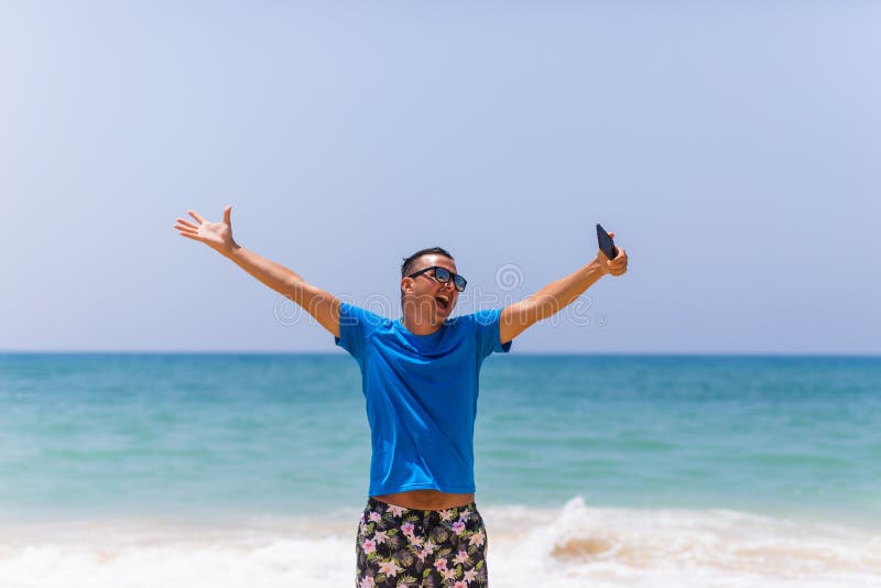 Hållmobiltelefonen för den unga mannen tar bilden av sikten för havet för sommarstranden den panorama- royaltyfri foto Hållmobiltelefonen för den unga mannen tar bilden av sikten för havet för sommarstranden den panorama- royaltyfri foto