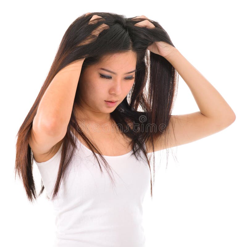 Young Asian girl scratches her hair on white background. Young Asian girl scratches her hair on white background