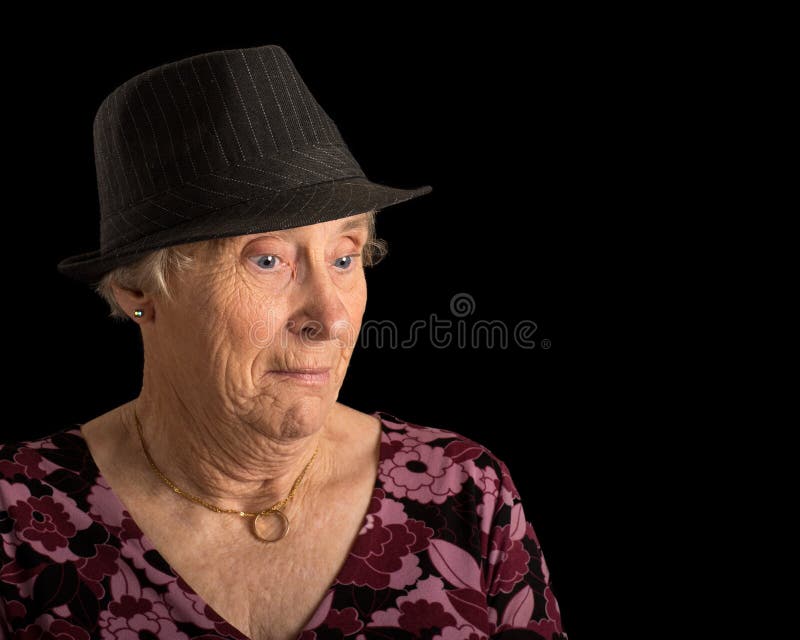 Hög dam med en chockad blick på hennes framsida som bär en fedora arkivfoton Hög dam med en chockad blick på hennes framsida som bär en fedora arkivfoton