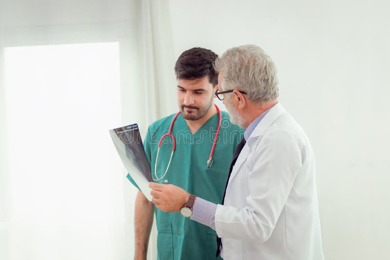Hög doktor för professor som förklarar fallstudien till hjälpabouen royaltyfri bild Hög doktor för professor som förklarar fallstudien till hjälpabouen royaltyfri bild