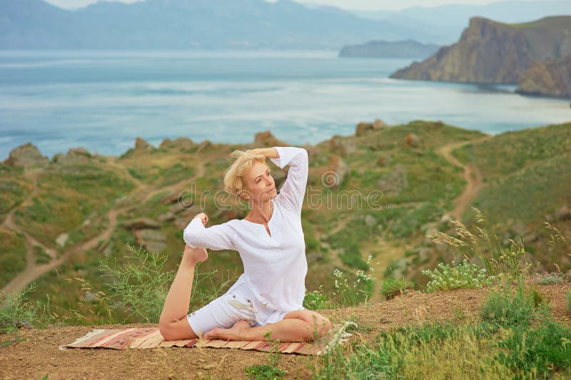 Hög kvinna som gör yogaövningar arkivfoto Hög kvinna som gör yogaövningar arkivfoto