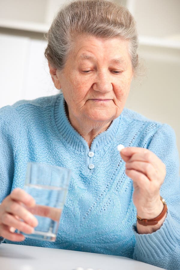 Close-up portrait of an older woman taking a medicine. Close-up portrait of an older woman taking a medicine