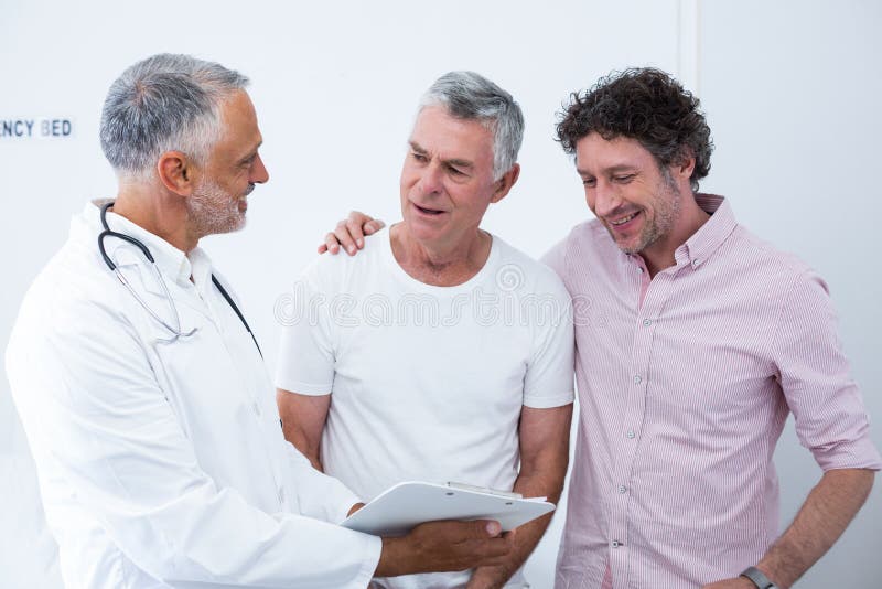 Senior men and his guardian talking to the doctor in hospital. Senior men and his guardian talking to the doctor in hospital