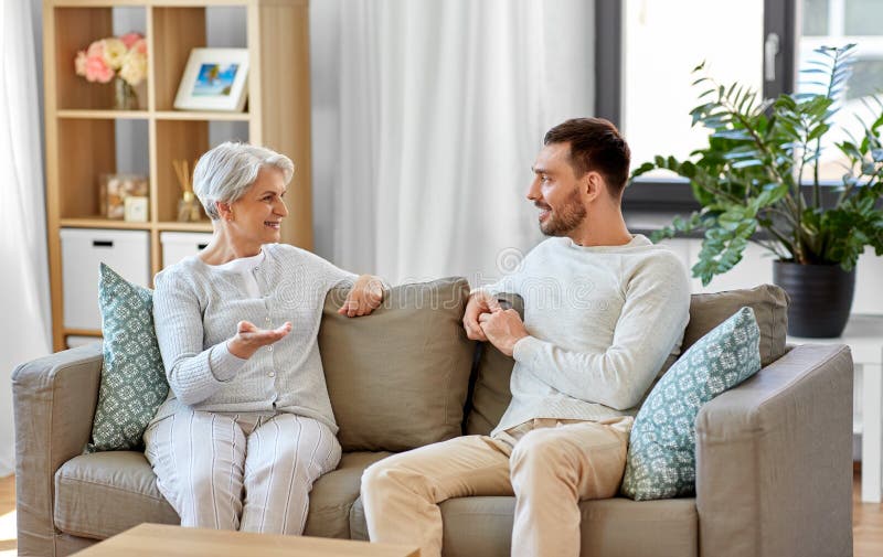 Hög moder som hemma talar till den vuxna sonen arkivbild Hög moder som hemma talar till den vuxna sonen arkivbild