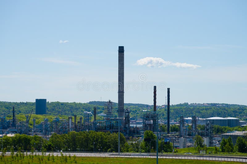 Gothenburg, Sweden - May 30 2023: Tall smoke stack at an oil refindery. Gothenburg, Sweden - May 30 2023: Tall smoke stack at an oil refindery.