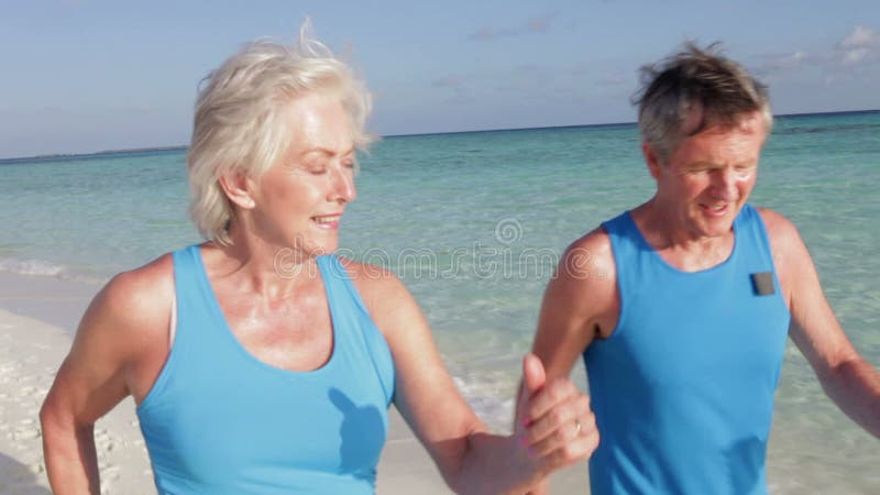 Höga par som går på den härliga stranden stock video