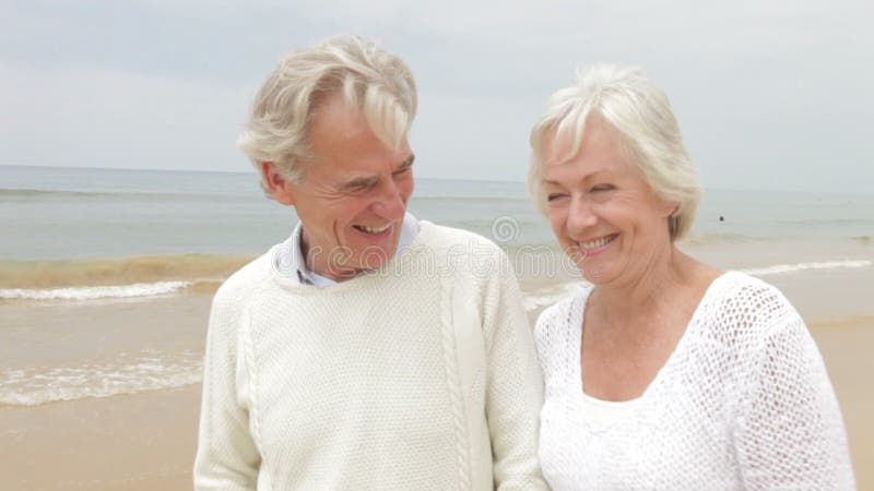 Höga par som promenerar Misty Beach arkivfilmer