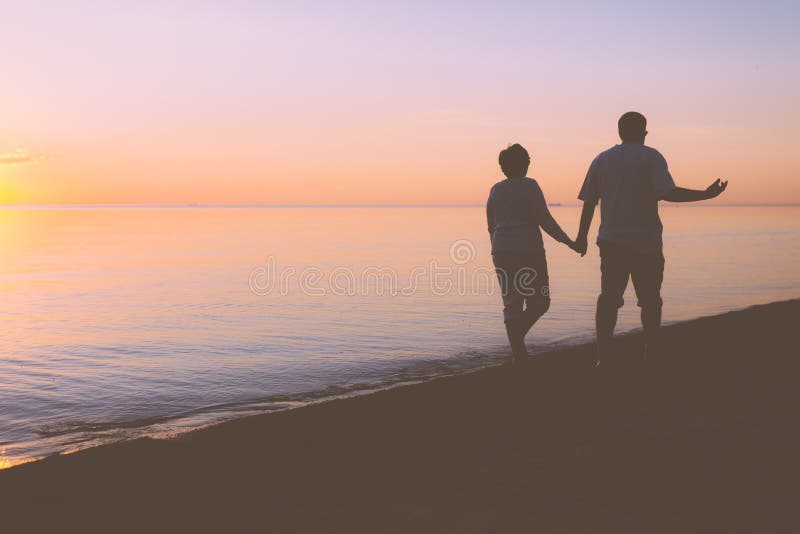 Höga par som promenerar stranden royaltyfria bilder Höga par som promenerar stranden royaltyfria bilder