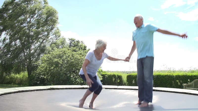 Höga par som studsar på trampolinen i ultrarapid lager videofilmer