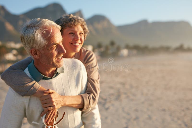 Höga par som tycker om deras semester på stranden