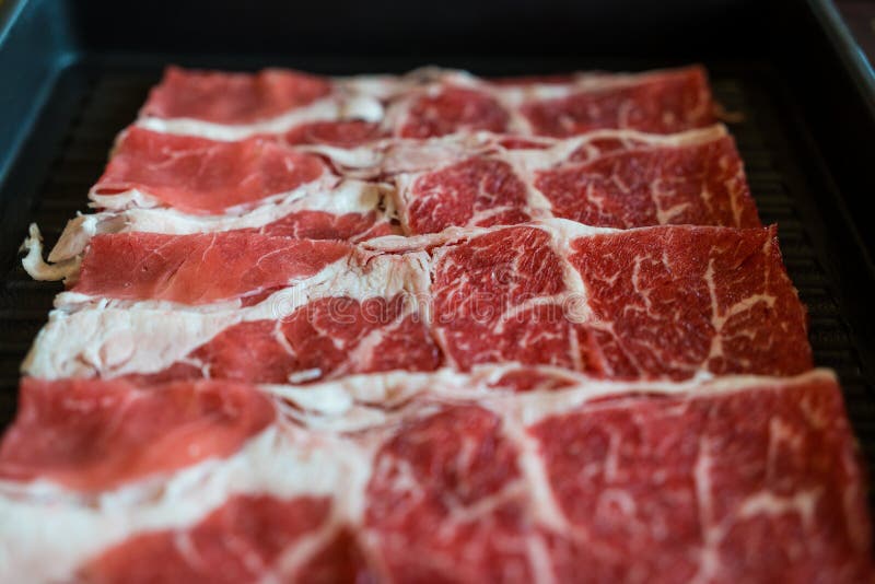 Högkvalitativt skivat nötkött med perfekt marmorerad textur för sukiyaki och shabu royaltyfria foton