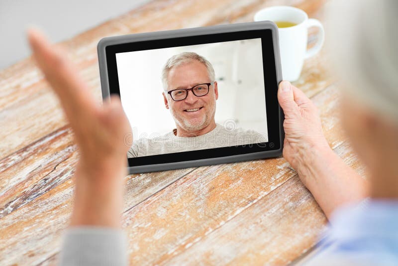 Högre kvinna som har videosamtal med högre man arkivfoton